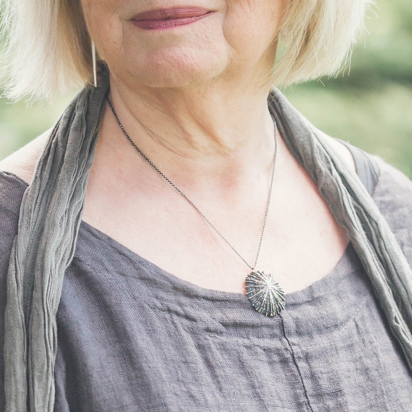 woman wearing a limpet necklace in oxidized silver