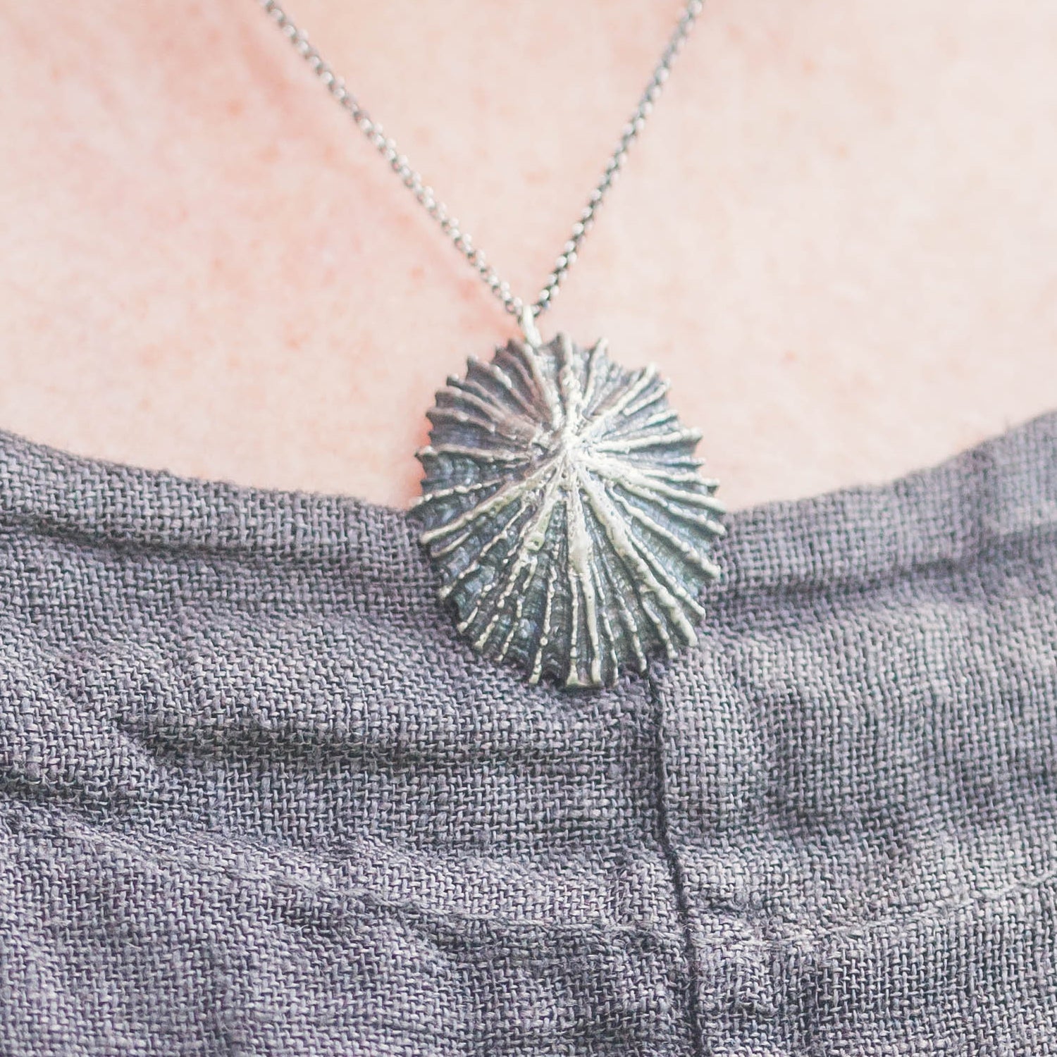 close up of oxidized silver limpet pendant being worn