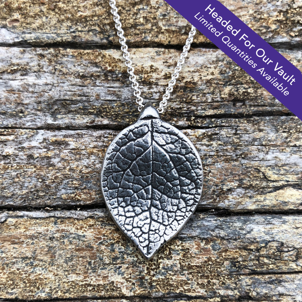 "Headed For Our Vault. Limited Quantities Available" large oxidized silver salal leaf pendant on wood grain background