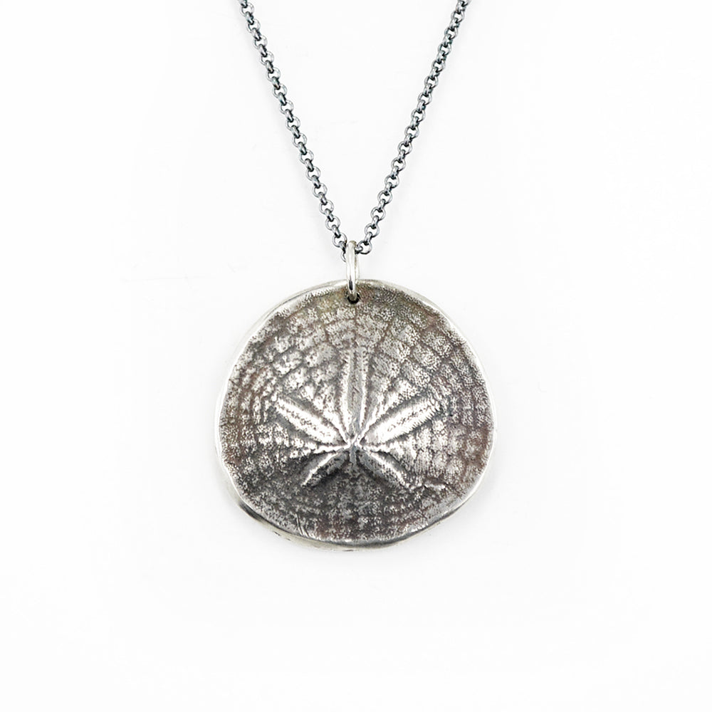 oxidized silver sand dollar pendant necklace on white background