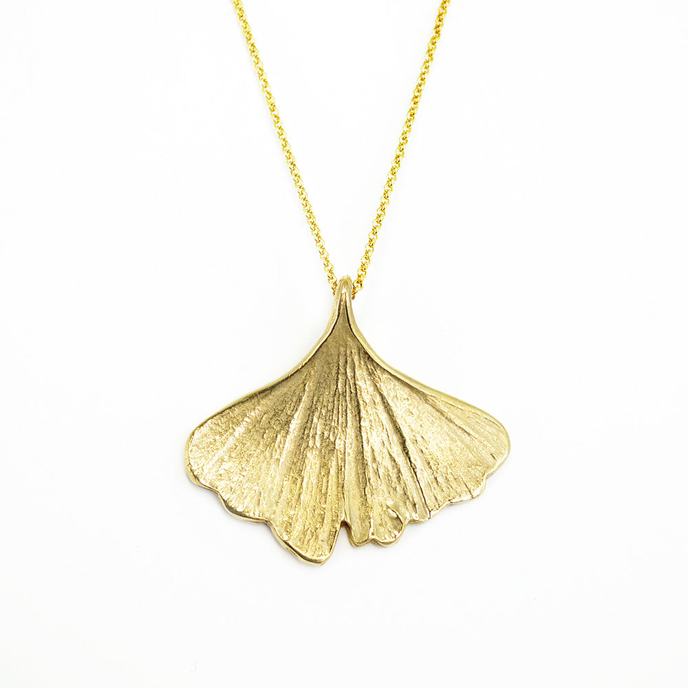 golden ginkgo necklace on white background