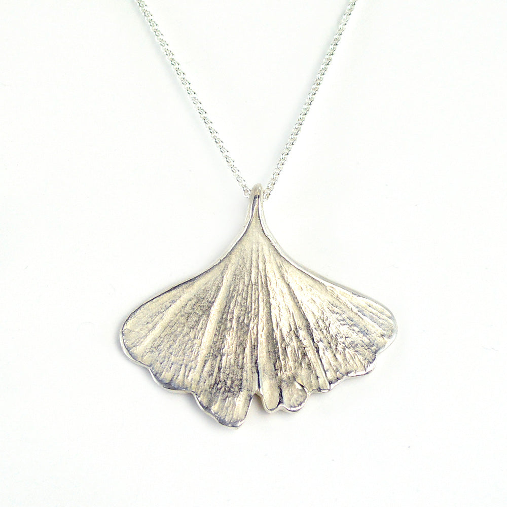 silver ginkgo leaf pendant necklace on white background