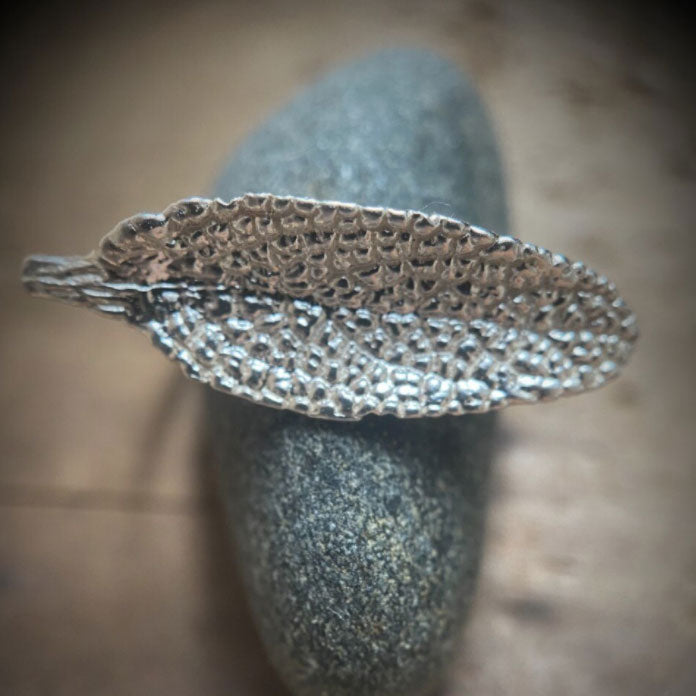 close up of sage leaf cast in sterling silver laid out horizontally as a ring