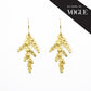 as seen in vogue. pair of golden cedar earrings on white background
