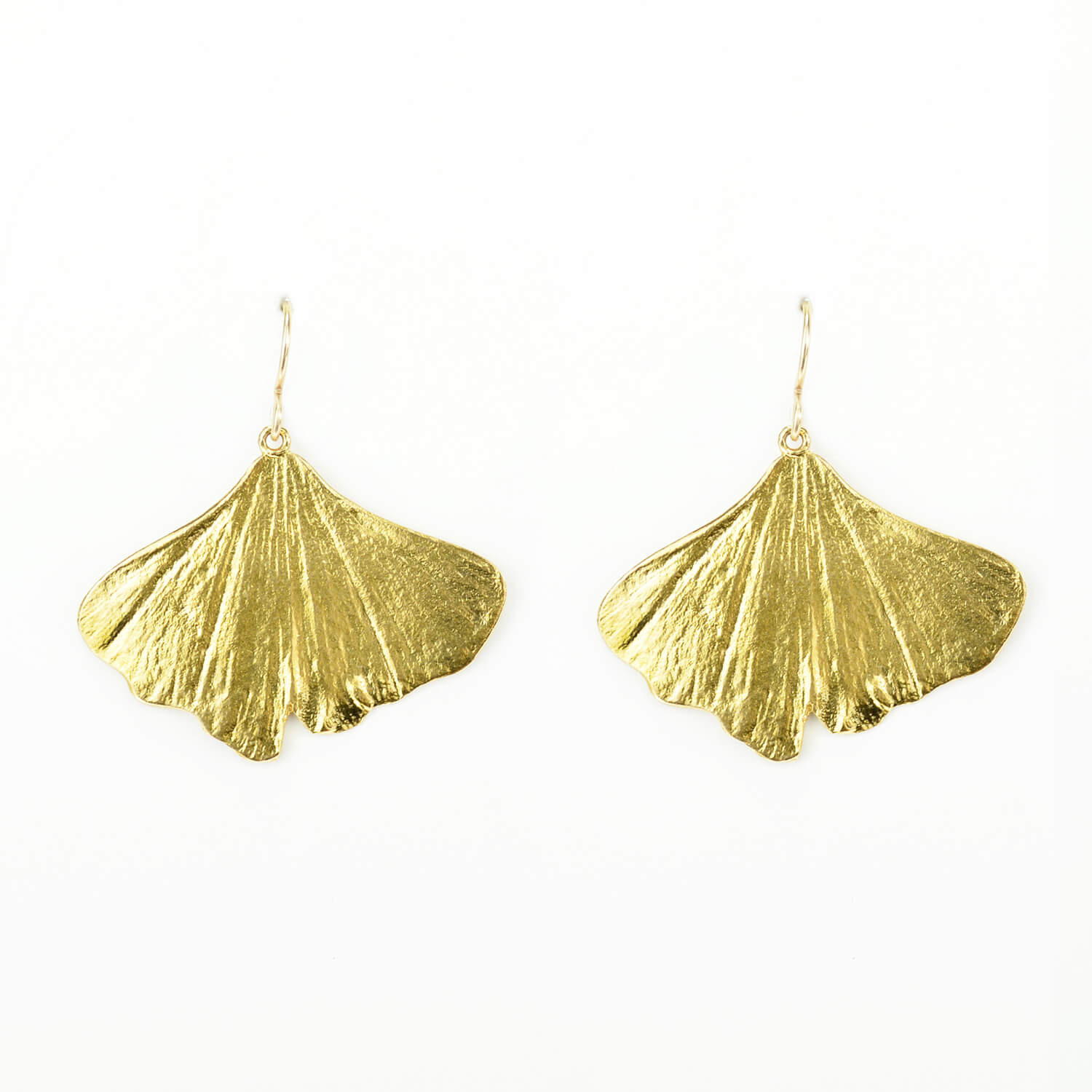 beautiful pair of golden ginkgo earrings on a white background 