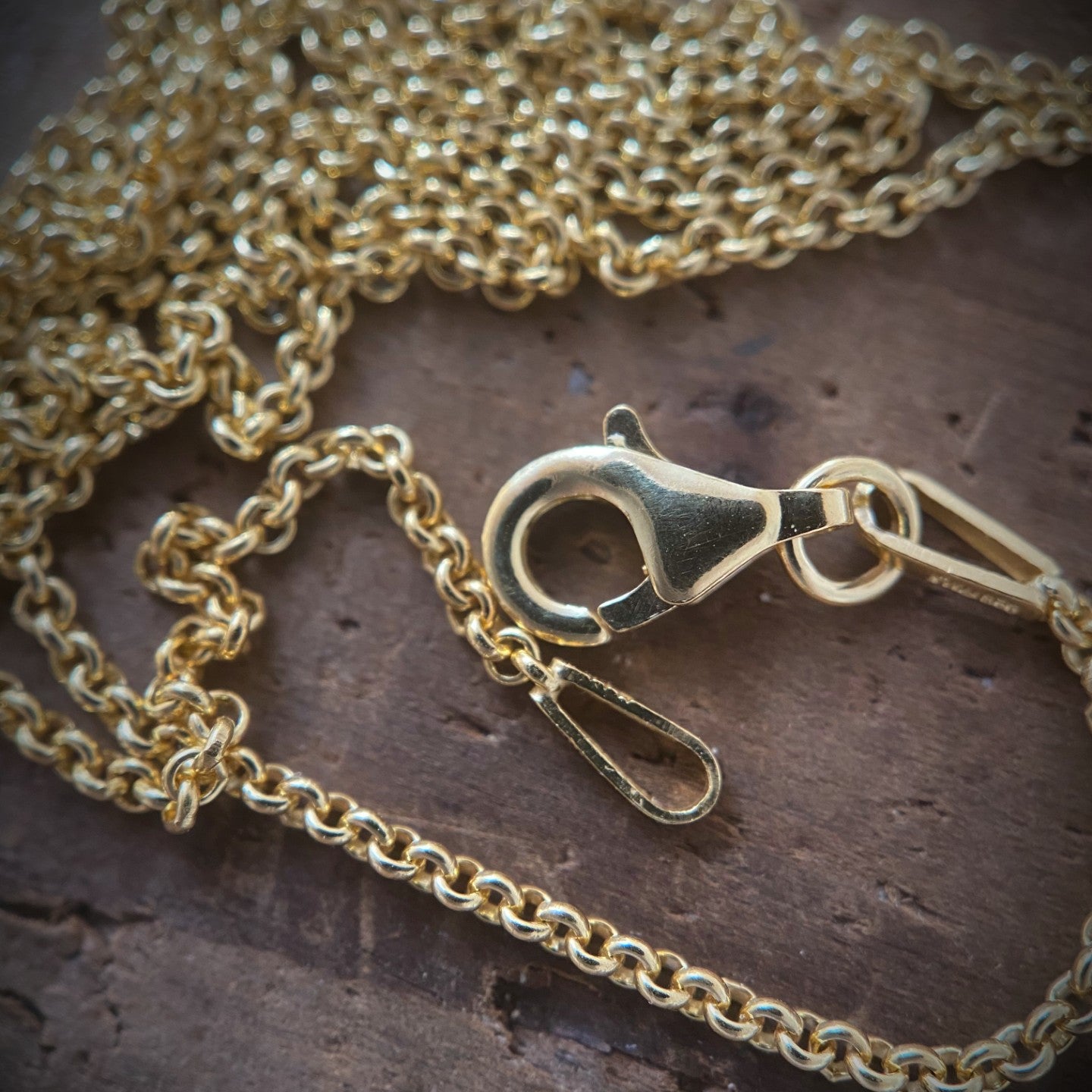 gold chain with lobster clasp on lovely wood background