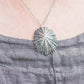 close up of oxidized silver limpet pendant being worn 