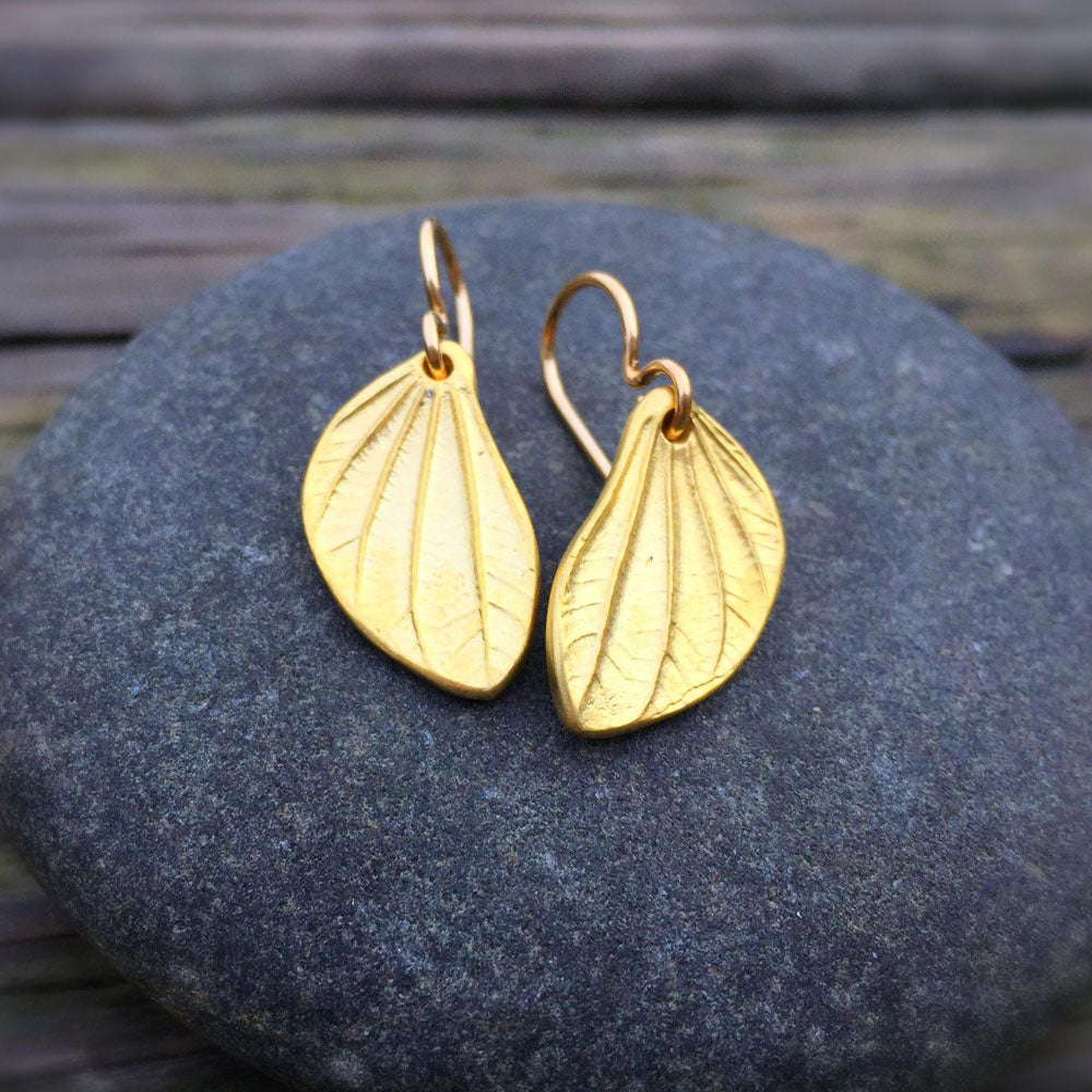 linden leaf pod earrings in golden bronze. sitting atop a round stone 