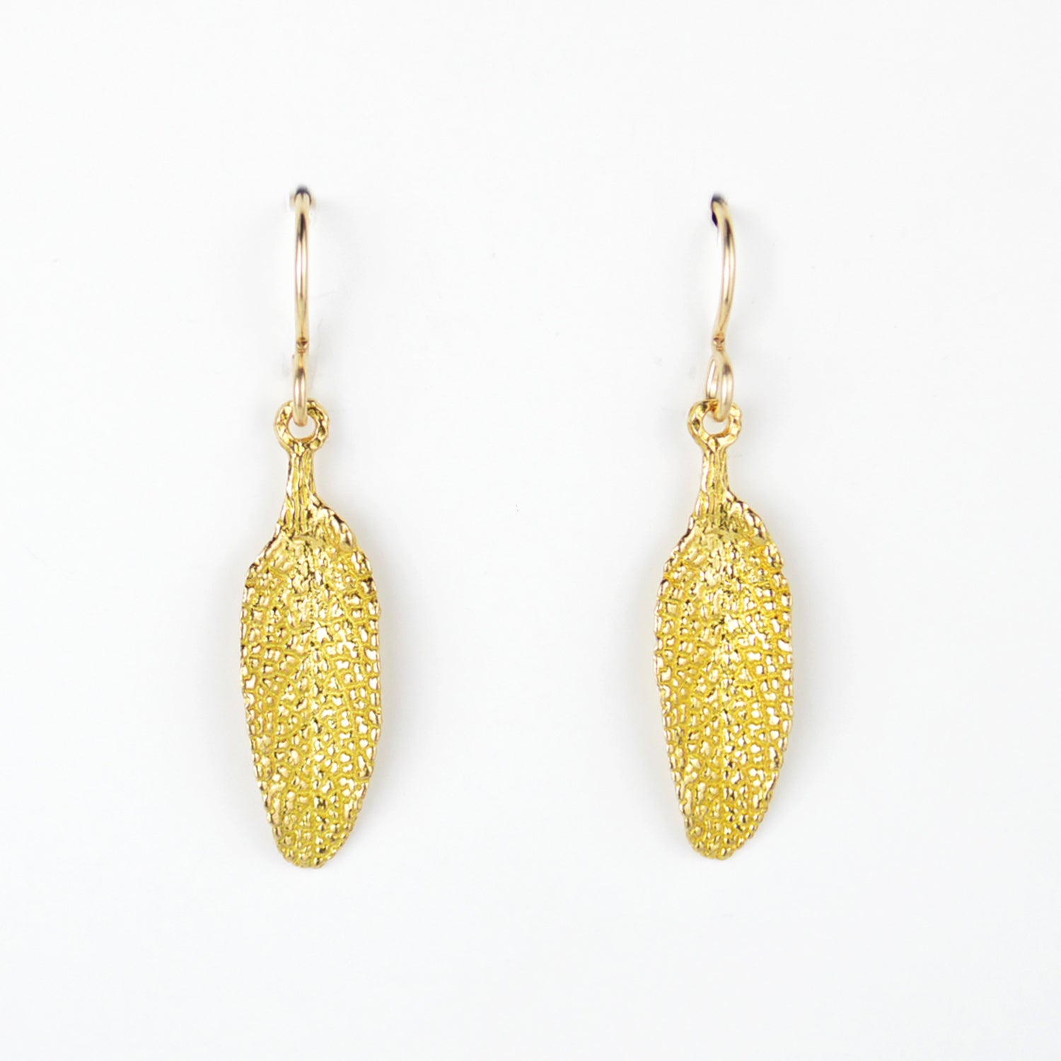 golden sage leaf earrings on plain white background. incredible detail