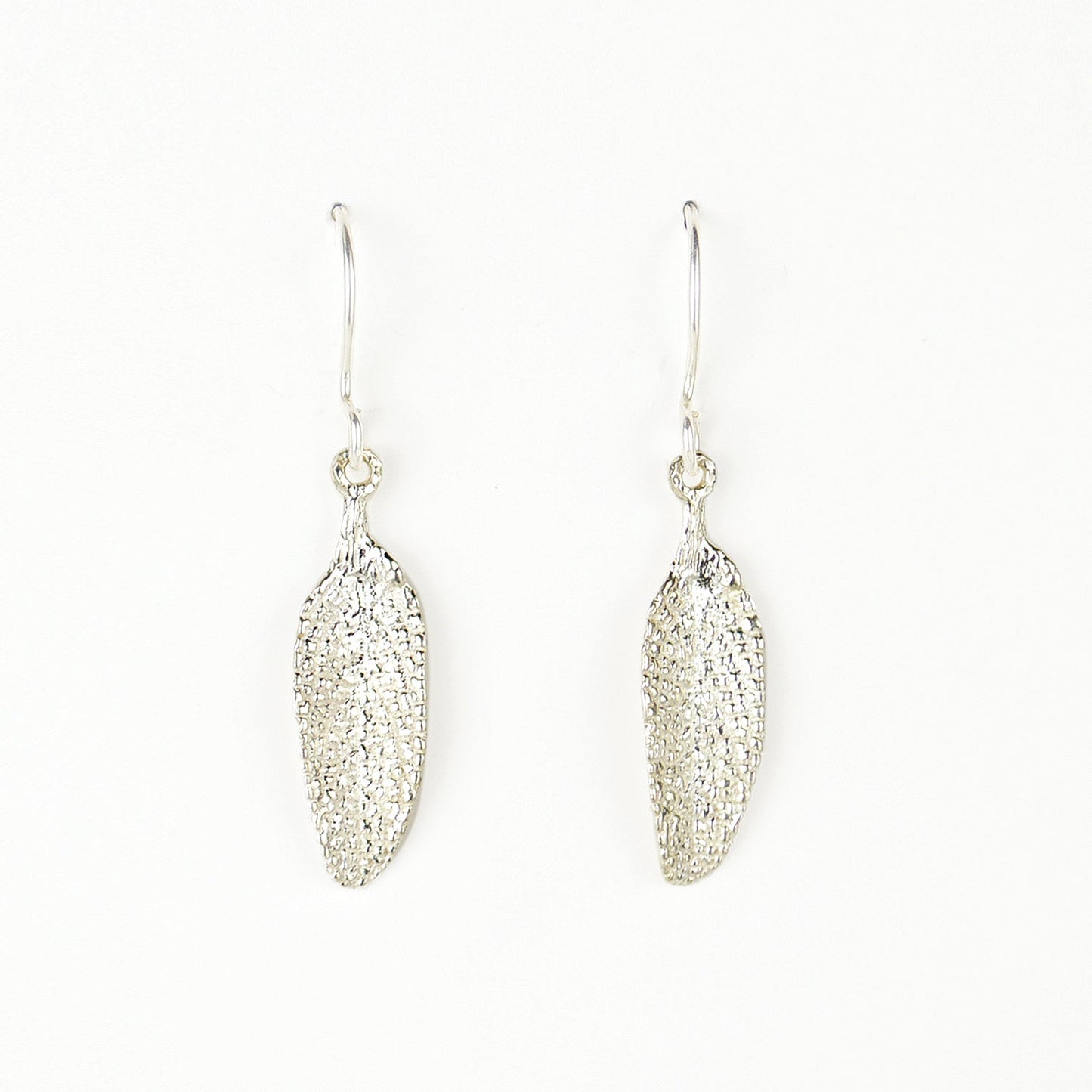 silver sage leaf earrings on plain white background. incredible detail