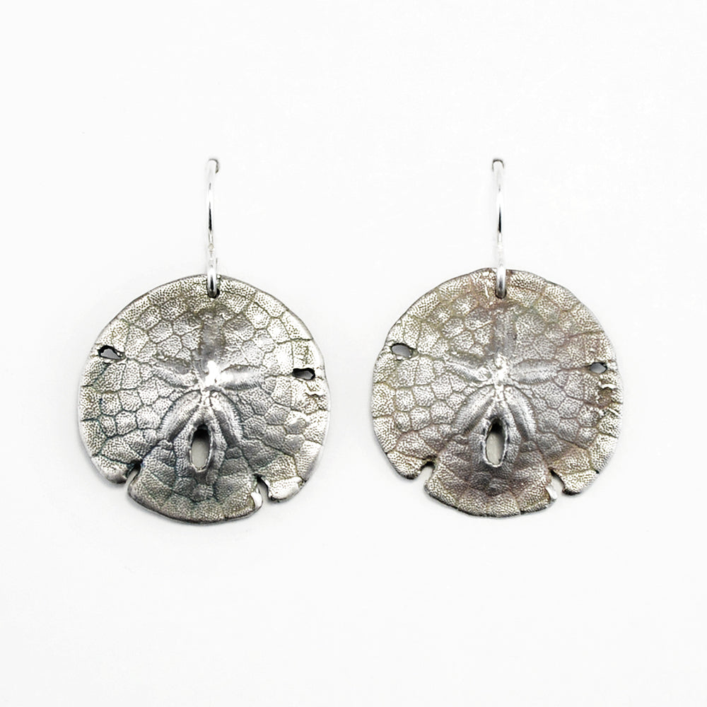 oxidized silver sand dollar shell earrings on a white background