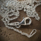 silver chain with lobster clasp on textured wood background