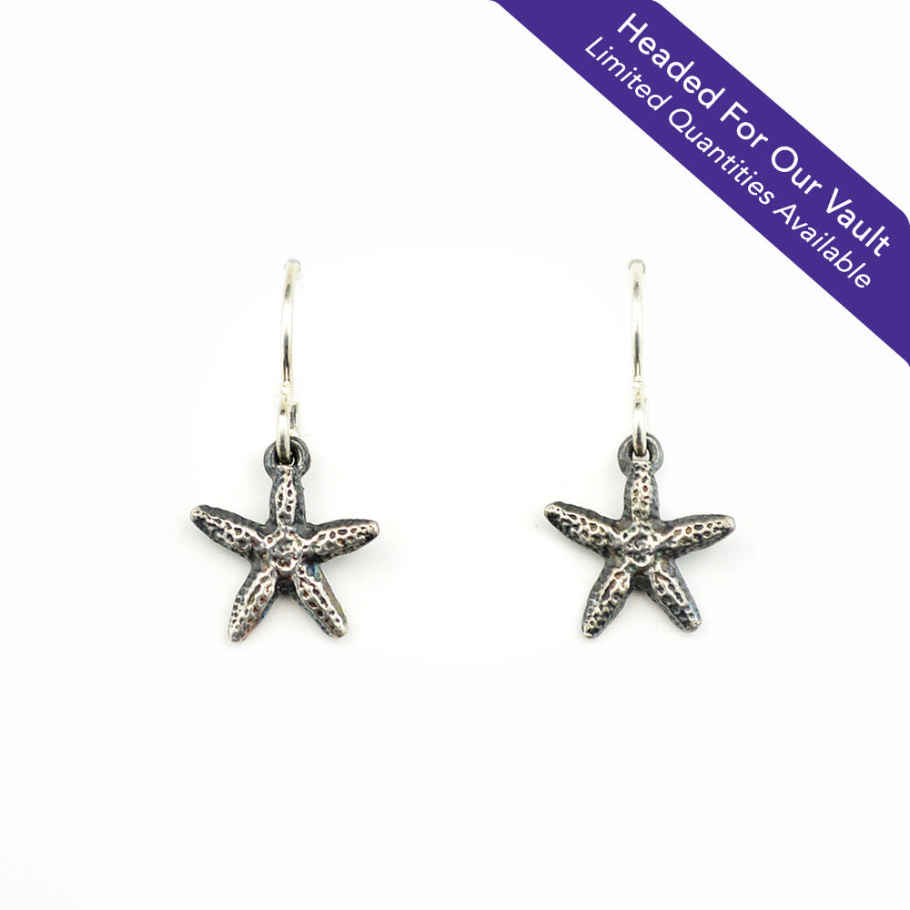 "Headed For Our Vault. Limited Quantities Available" small oxidized silver starfish earrings on a white background