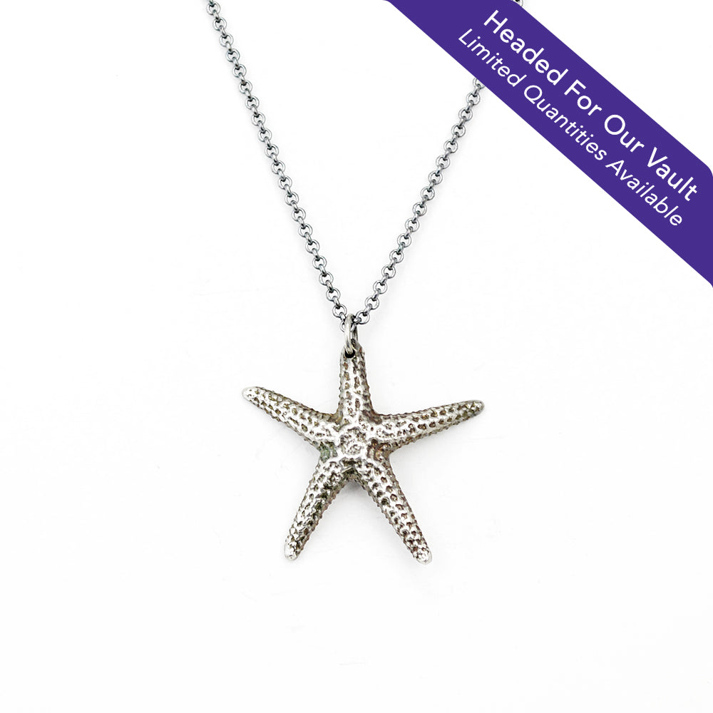 "Headed For Our Vault. Limited Quantities Available" starfish pendant in oxidized sterling silver on white background