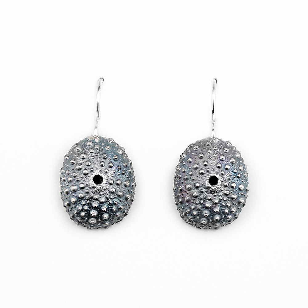 pair of beautifully detailed oxidized silver sea urchin shell earrings on white background