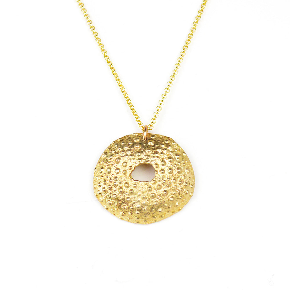 golden sea urchin necklace on white background