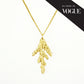 "As seen in Vogue" gold cedar necklace on white background