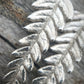 up close image of silver fern earring details 