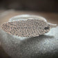 close up of sage leaf cast in sterling silver laid out horizontally as a ring